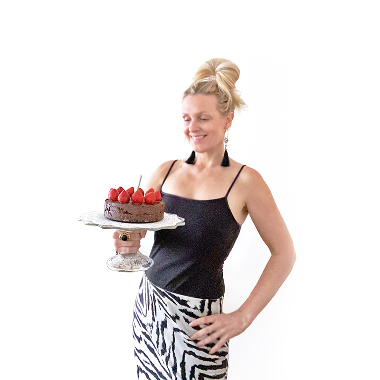 Yvonne Hedberg håller i en raw chokladtårta med jordgubbar.