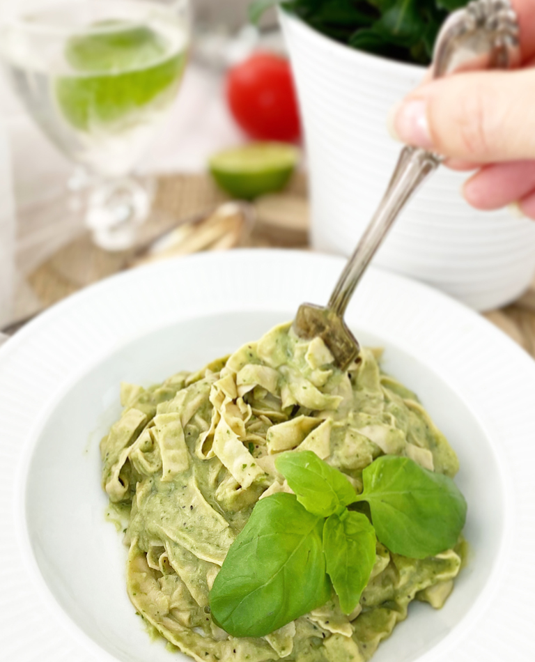 En djup tallrik med vegansk och glutenfri pastasås på avokado och bönpasta.