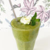 Ett glas med en vegansk grön selleri smoothie.