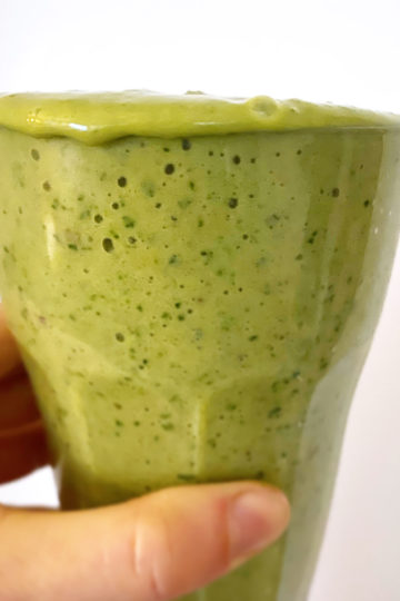 En glas med grön vegansk smoothie.