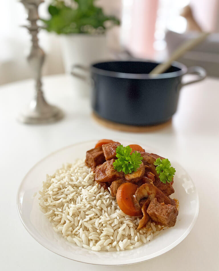 Ett fat med tofugryta och ris står framför en gryta.